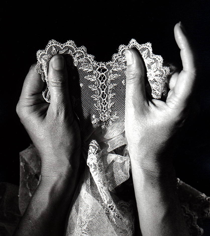 La Perla lace held between an artisan’s hands.